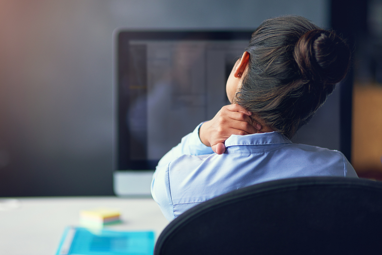 Ergonomie au travail : une femme assise à son bureau souffre de troubles musculosquelettiques (tms)